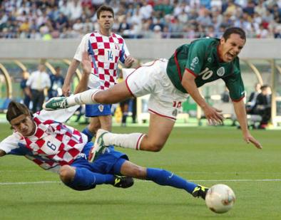 CROATIA'S ZIVKOVIC BRINGS DOWN MEXICO'S BLANCO DURING THEIR WORLD CUP FINALS MATCH IN NIIGATA